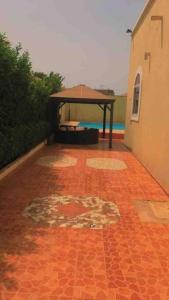 a red brick floor with a pavilion next to a building at 3 bdr pool house near Brusubi and brufut Heights in Brufut