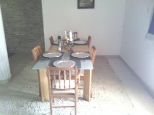 - une table à manger avec des chaises et des assiettes dans l'établissement 3 bdr pool house near Brusubi and brufut Heights, à Brufut