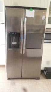 - un réfrigérateur en acier inoxydable avec distributeur d'eau dans la cuisine dans l'établissement 3 bdr pool house near Brusubi and brufut Heights, à Brufut