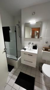 a bathroom with a sink and a shower and a toilet at BOSTEL 54 - Moderne Stadtwohnung in Moers-Zentrum in Moers