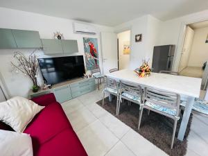 una cucina con tavolo, sedie e TV di Villa Greif Pineta a Lignano Sabbiadoro