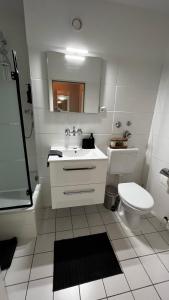 a bathroom with a sink and a toilet and a mirror at BOSTEL 54 - Moderne Stadtwohnung in Moers-Zentrum in Moers