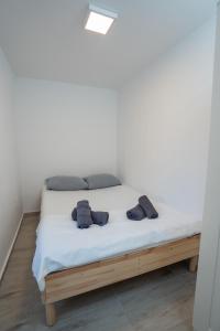 a bed with two pairs of shoes on it at Ricky Apartments in Novalja