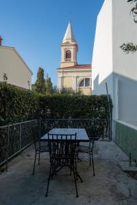 a table and chairs in front of a building with a tower at Ricky Apartments in Novalja