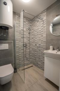 a bathroom with a shower and a toilet and a sink at Ricky Apartments in Novalja