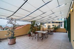 een patio met een tafel en stoelen op een balkon bij Hotel Globo Suite-Correnti hotels in Sanremo