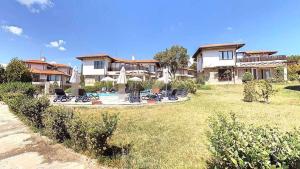 a house with a yard with chairs and a pool at Villa Rada, Bay View Villas in Kosharitsa