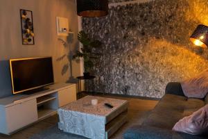 ein Wohnzimmer mit einem Sofa, einem TV und einem Tisch in der Unterkunft Ferienwohnung Auetal 
