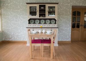 a wooden table with bowls and plates on it at The Roses B&B in Portree