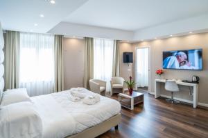 - une chambre avec un lit blanc, un bureau et des chaises dans l'établissement Hotel Globo Suite-Correnti hotels, à Sanremo