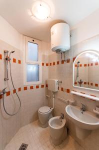 uma casa de banho com um WC, um lavatório e um chuveiro em Villaggio Tivoli em Bibione