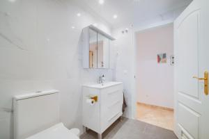 um banheiro branco com uma pia e um espelho em JAZMIN MIRAFLORES SENSATIONAL VIEW! POOL, TERRACE, WiFi em La Cala de Mijas