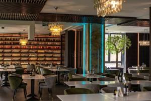 a restaurant with tables and chairs and a wall of books at Silver Mountain Resort & Spa in Poiana Brasov
