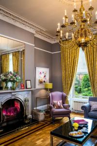 a living room with a fireplace and a chandelier at Roxford Lodge Hotel in Dublin