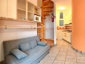 uma sala de estar com um sofá e uma cozinha em Villaggio Tivoli em Bibione