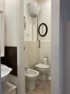 a white bathroom with a toilet and a sink at Cestello Luxury Rooms in Florence