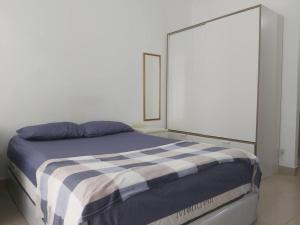 雅加達的住宿－The Nest Dipuri，一间卧室配有一张带蓝白色毯子的床