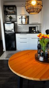 a kitchen with a wooden table and a table with flowers at BOSTEL 54 - Moderne Stadtwohnung in Moers-Zentrum in Moers