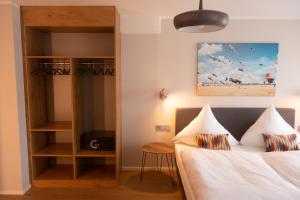 een slaapkamer met een bed en een boekenplank bij Hotel Herrnbrod & Ständecke in Dreieich