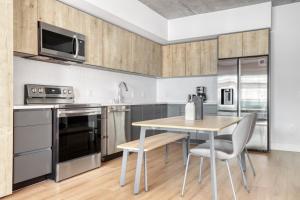 a kitchen with stainless steel appliances and a table with chairs at Downtown 1BR w Pool Gym WD nr Staples Center LAX-543 in Los Angeles