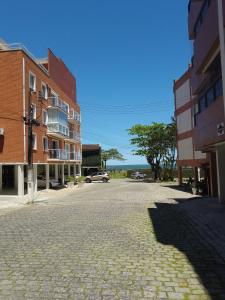 Apartamento familiar com acesso privativo à Praia Mansa في ماتينيوس: شارع فاضي في مدينه فيها مباني