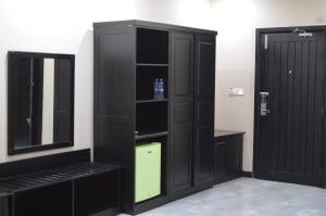 a black cabinet with a mirror in a bathroom at Palm Kalash Hotel in Lusaka