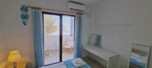 Schlafzimmer mit einem Bett, einem TV und einem Fenster in der Unterkunft STAY EasyDream Maisonette in Paralimni