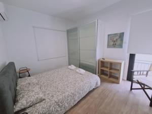 a white bedroom with a bed and a chair at STAY Vintage House in Limassol