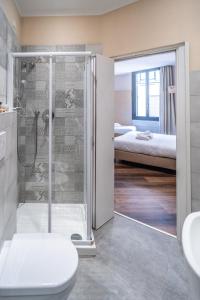 a bathroom with a shower and a toilet and a bedroom at Hotel Globo Suite-Correnti hotels in Sanremo