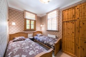 a bedroom with two beds and a cabinet at Cottage Dzintars in Jūrmala