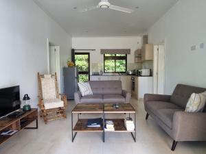 a living room with two couches and a coffee table at Villa Laure in Grand'Anse Praslin