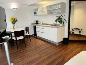 cocina y comedor con mesa y barra en Awwa Suites & Spa en Buenos Aires