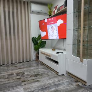 a living room with a tv on a wall at Nandos Apartement in Costa da Caparica
