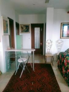 ein Wohnzimmer mit einem Glastisch und Stühlen in der Unterkunft Appartamento formula residence in Casavecchie
