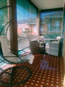 Zimmer mit einem Stuhl und einem Balkon mit Fenstern in der Unterkunft Appartamento formula residence in Casavecchie