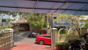 czerwony samochód stoi pod niebieskim baldachimem w obiekcie The Padmavathi Guest House - Vizag w mieście Visakhapatnam