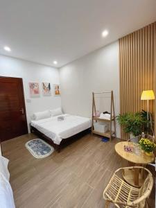 1 dormitorio con 1 cama grande y 1 mesa en LaLa Citadel Homestay en Hue