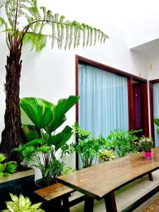 una mesa de picnic de madera en una habitación con plantas en LaLa Citadel Homestay en Hue