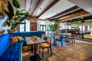 Bistrotel 't Amsterdammertje في Nieuwersluis: مطعم فيه اريكه زرقاء وطاولات وكراسي