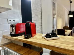 una tostadora roja sobre un mostrador de madera en Bright loft city centre by United Renters, en Alicante