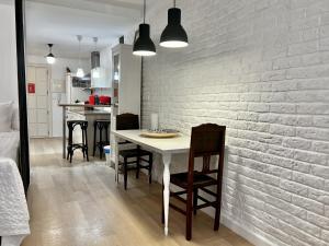 cocina y comedor con pared de ladrillo blanco en Bright loft city centre by United Renters, en Alicante