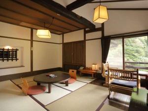 a living room with a table and chairs in a room at Fujiya in Minamioguni