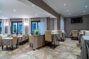 un restaurante con mesas y sillas en una habitación en Hotel Globo Suite-Correnti hotels, en San Remo