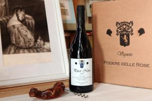 - une bouteille de vin à côté d'une boîte dans l'établissement Podere Delle Rose, à Torre San Severo