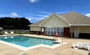 a swimming pool in front of a house at Boll Weevil Cottage in Enterprise