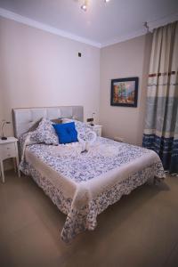 a bedroom with a large bed with blue pillows at Hotel Bajamar Centro in Nerja