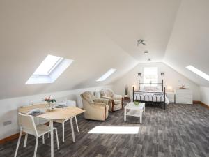 a living room with skylights and a table and chairs at Cwt Ci in Llangefni