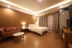 釜山Hotel Prima Busan的配有床和沙发的酒店房间