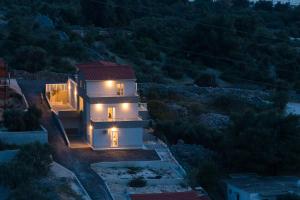a house with lights on top of it at night at Apartments Sucic in Sevid