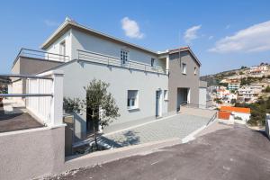 a white house with a hill in the background at Apartments Sucic in Sevid